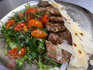 ein Teller mit Fleisch und Gemüse darauf in der Unterkunft Casa Mignon in Oradea