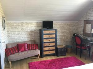 ein Wohnzimmer mit einem Sofa und einer Kommode in der Unterkunft Mille et Une Bulles 51 in Brugny-Vaudancourt