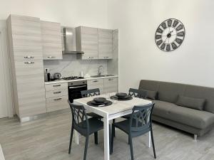 a kitchen and a dining room with a table and chairs at Room 28 in Conversano