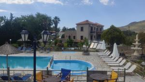 a resort with a pool and chairs and a building at Ourania Studios in Petra