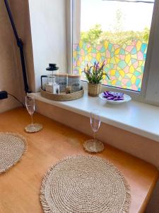 a window sill with two wine glasses and a table at Uuemõisa apart in Haapsalu +10 photos