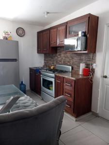 マサトランにあるRenta Vacacional Zoeの木製のキャビネットとコンロ付きオーブンを備えたキッチン