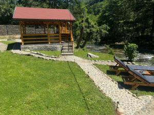 a gazebo with a picnic table in the grass at Woods Retreat in Râu de Mori