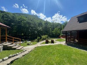 a backyard with a building and a grass yard at Woods Retreat in Rîu de Mori +33 photos