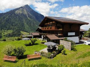 een gebouw met banken en paraplu's ervoor bij Bergblick Lodge - 3 Sterne Garni - Neueröffnung in Aeschi