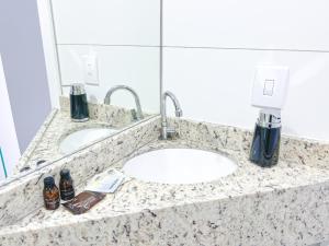 a bathroom counter with two sinks and a mirror at Pousada da Bia Praia in Penha
