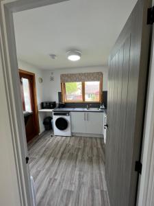 a kitchen with a washer and dryer in a room at The Wee Hoose near Loch Ness, private garden, private parking in Drumnadrochit