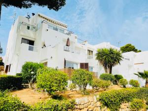 a white building with trees in front of it at Eco del Mar in Cala d´Or