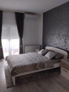 una camera da letto con un letto grande davanti a una finestra di Apartman Lenka a Sremska Mitrovica