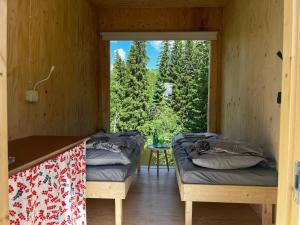 two beds in a room with a large window at KoloCabins - Hiitolanjoki 3 in Simpele
