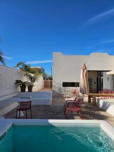 a house with a swimming pool and a table and chairs at Casa Aria by Jdvacanze in San Pietro in Bevagna