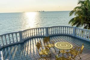 a table and chairs on a balcony overlooking the water at Sound of the Sea Villa PD in Port Dickson +12 photos