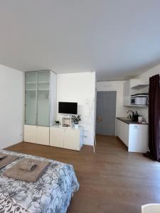 a white room with a bed and a kitchen at Formai Living apartments in Trento