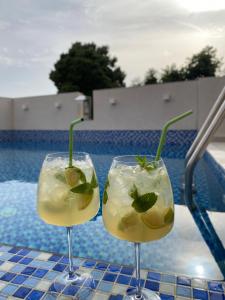 two cocktails in glasses on a table next to a pool at Villa Ivanovic in Budva