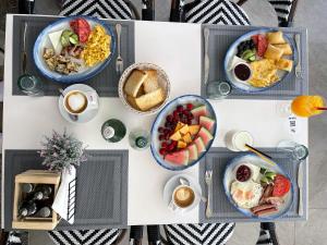 a table with bowls of breakfast food on it at Hotel Villa Kapo Pool & Bar in Ksamil