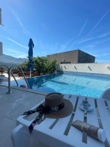 a hat sitting on a bench next to a swimming pool at Villa Ivanovic in Budva