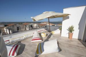 a patio with pillows and an umbrella on a balcony at Casa Alexina in Lesina