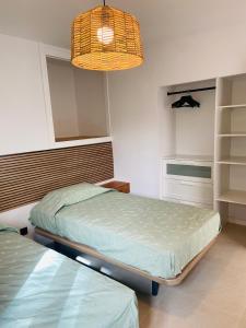 a bedroom with two beds and a chandelier at Eco del Mar in Cala d´Or +22 photos