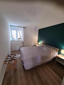 a bedroom with a bed and a green wall at Appartement au pied des pistes avec grande terrasse in Orbey