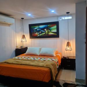 a bedroom with a bed with a painting on the wall at HOTEL AVENIDA 22 Sector de escenarios deportivos y clinicas in Santa Marta