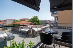 a balcony with a table and chairs and a city at sarti luxury diaMoNd in Sarti