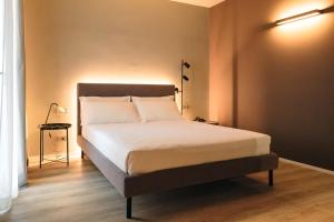 a bedroom with a bed in a room with a lamp at Camoma Aparthotel - Boutique Hotel & Suites in Jesolo