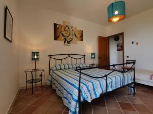 sypialnia z łóżkiem z niebiesko-białą kołdrą o paskach w obiekcie Bouganville Home w mieście Vietri sul Mare