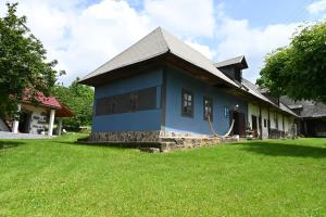 a blue house with a grass yard in front of it at Modrá chalupa in Pliešovce +39 photos