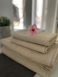a stack of towels with a pink flower on top at Casa Mia Bogliasco Mare & Centro in Bogliasco +42 photos