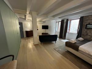 a bedroom with a bed and a chair in a room at Studios OneThreeFive in Rovinj