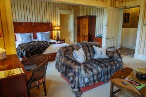 une chambre d'hôtel avec un lit, un canapé et un lit dans l'établissement Horsted Place Hotel, à Uckfield