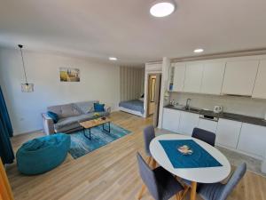 a kitchen and a living room with a table and a couch at Square Studio Tuzla in Tuzla
