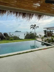 ein Swimmingpool mit Blick auf das Meer in der Unterkunft Sitaya Beachfront Villas, Koh Phangan in Ko Phangan