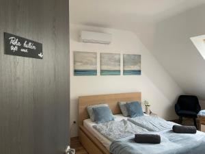 a bedroom with two beds with blue pillows at Belle Apartman in Balatonlelle