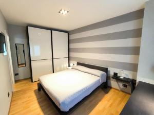 a bedroom with a bed and a striped wall at Casa Dina in Baveno