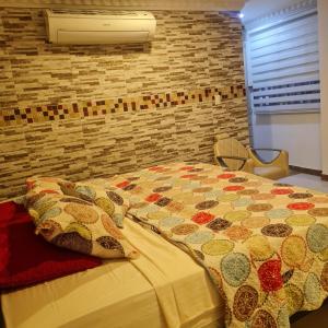 a bedroom with a bed with a quilt on it at HOTEL AVENIDA 22 Sector de escenarios deportivos y clinicas in Santa Marta