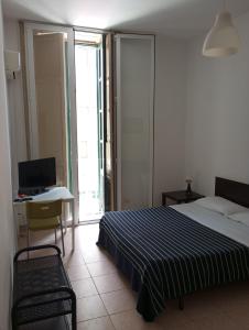 a bedroom with a bed and a desk and a window at B&B CARAVAGGIO SIRACUSA 200 Metres from Ortigia in Siracusa