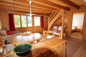 una sala da pranzo e un soggiorno in una baita di tronchi di Le Gros Pâquier a La Lécherette