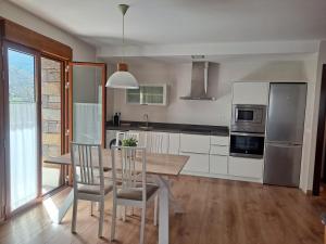 a kitchen with a table and chairs and a refrigerator at Apartamento Culfreda in San Juan de Plan