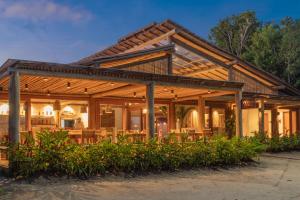 a house with a wooden roof at Pousada Nossa Casa Cumuruxatiba in Cumuruxatiba