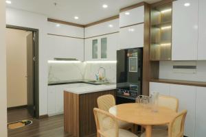 a kitchen with a wooden table and a kitchen with white cabinets at HOMESTAY nhà Trang in Hai Phong