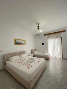a bedroom with a large bed with red flowers on it at Green Garden Villa in Ksamil