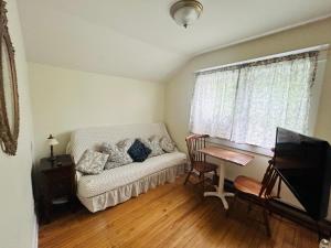 a living room with a white couch and a table at Auberge De Mon Petit Chum B&B in Wakefield