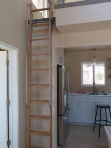 a loft bed in a kitchen with a ladder at Loyah Cabin in Ahwahnee