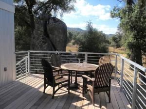 a wooden deck with a table and chairs on it at Loyah Cabin in Ahwahnee