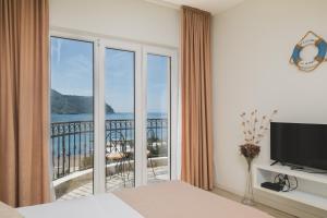 a bedroom with a large window with a view of the ocean at Villas Promis in Čanj