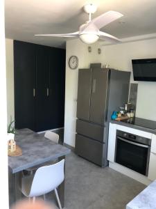 a kitchen with a black refrigerator and a table at Chambre avec salle d'eau privée dans appartement partagé 200 m du tram in Montpellier +2 photos