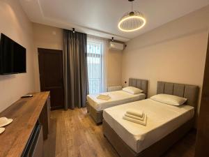 una camera d'albergo con due letti e una scrivania di Ameli Apartments BTM a Batumi