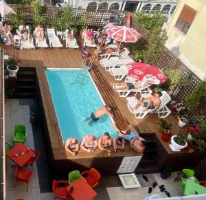 a group of people laying around a swimming pool at Sunrise Hotel Cameria in Durrës