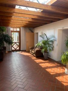 萨尔斯塔特Apartment mit eine große Terasse Nähe Hannover-Messe的带木质天花板和盆栽的客厅